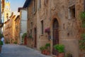 Pienza, Italy Ã¢â¬â May 27, 2017: Beautiful narrow street with sunlight and flowers in the village of Pienza, Italy Royalty Free Stock Photo